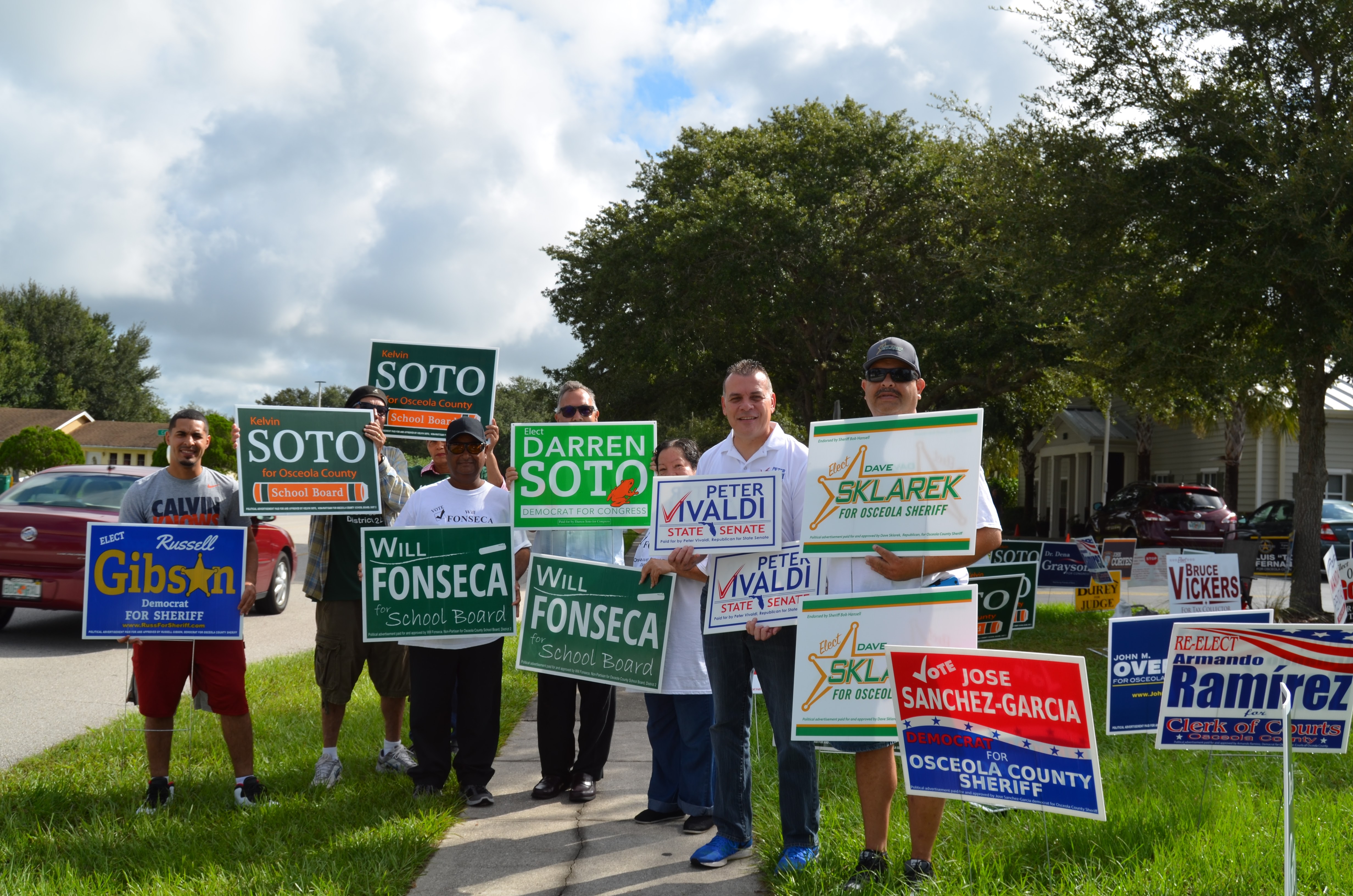 Simpatizantes de varios candidatos de la Florida Central buscan el voto de los ciudadanos antes de que éstos entren a los precintos en las primarias del 30 de agosto de 2016.
