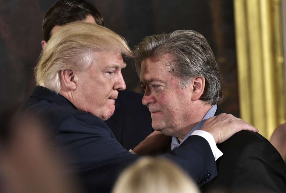 El presidente Donald Trump felicita a su asesor principal Stephen Bannon durante el juramento del equipo presidencial.