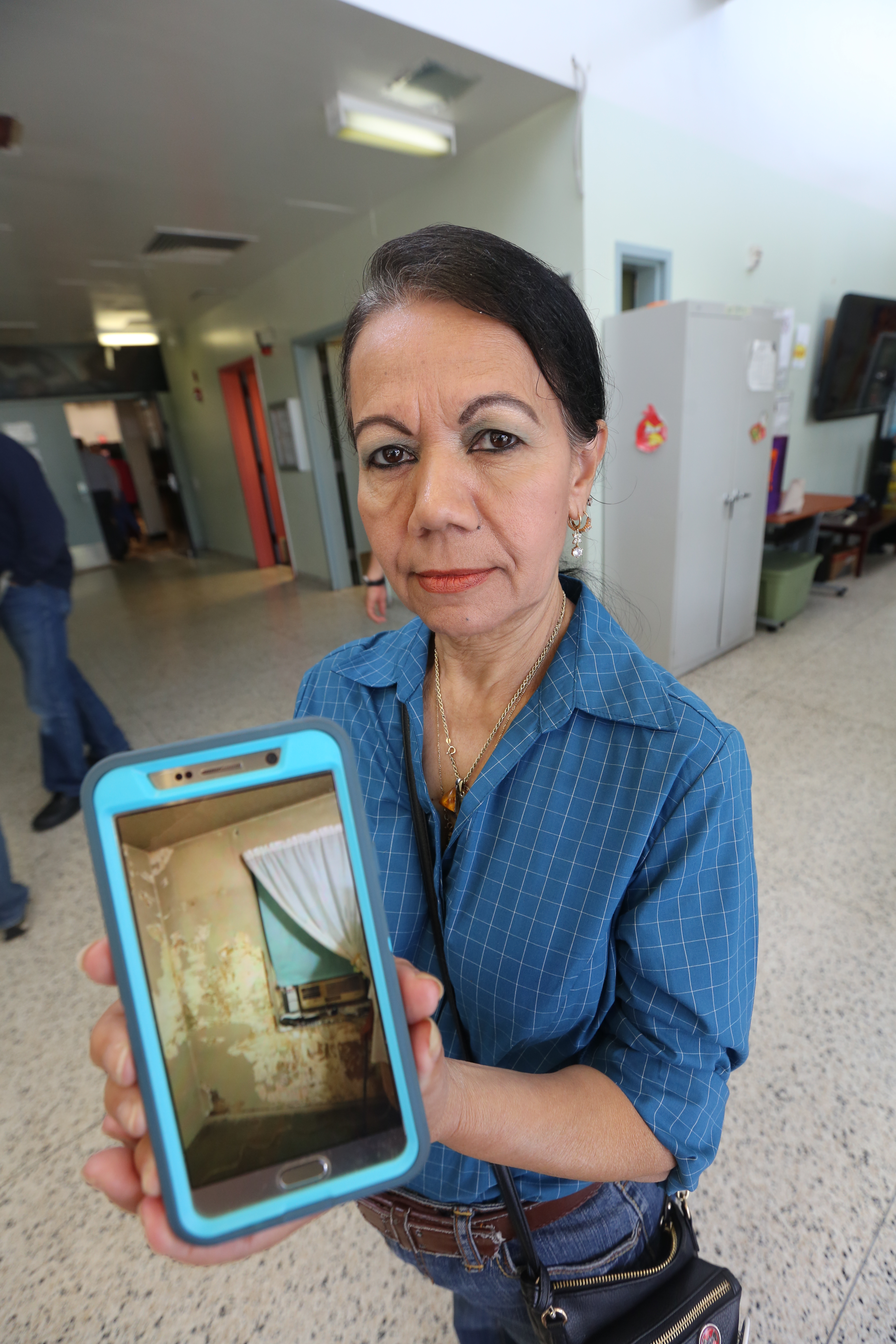 Inquilina Juana Narvaez muestra una foto del moho en su celular. Concejales Carlos Menchaca y Ritchie Torres durante una audiencia sobre el moho en los departamentos de NYCHA en Red Hook, Brooklyn.