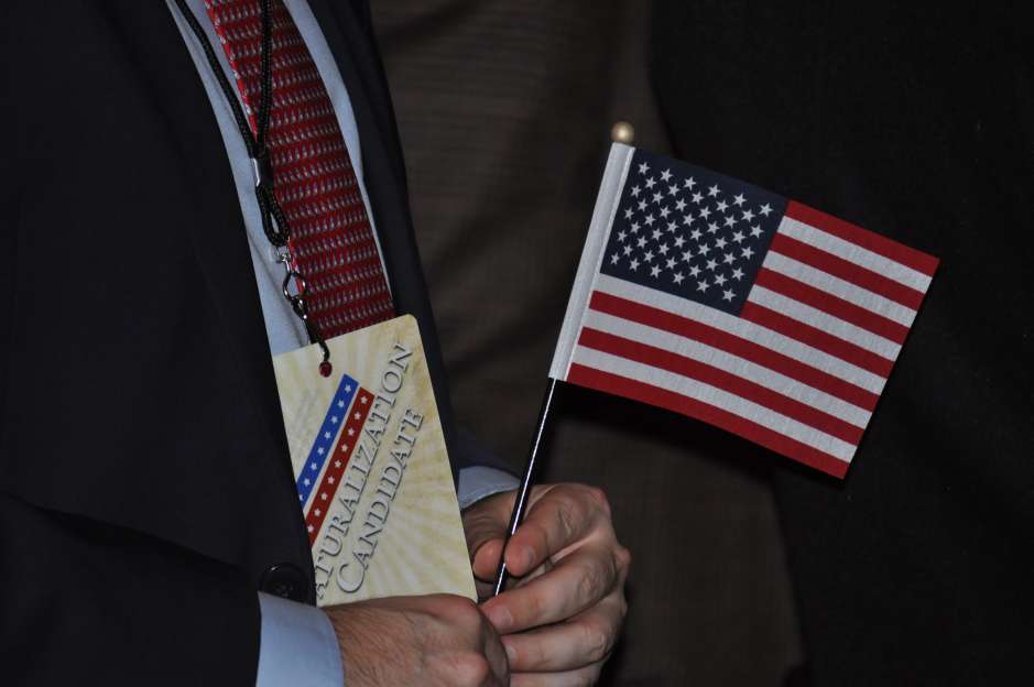 Uno de los nuevos ciudadanos estadounidenses sujeta una bandera de Estados Unidos en la ceremonia de naturalización 10 de abril en el edificio del New-York Historical Society