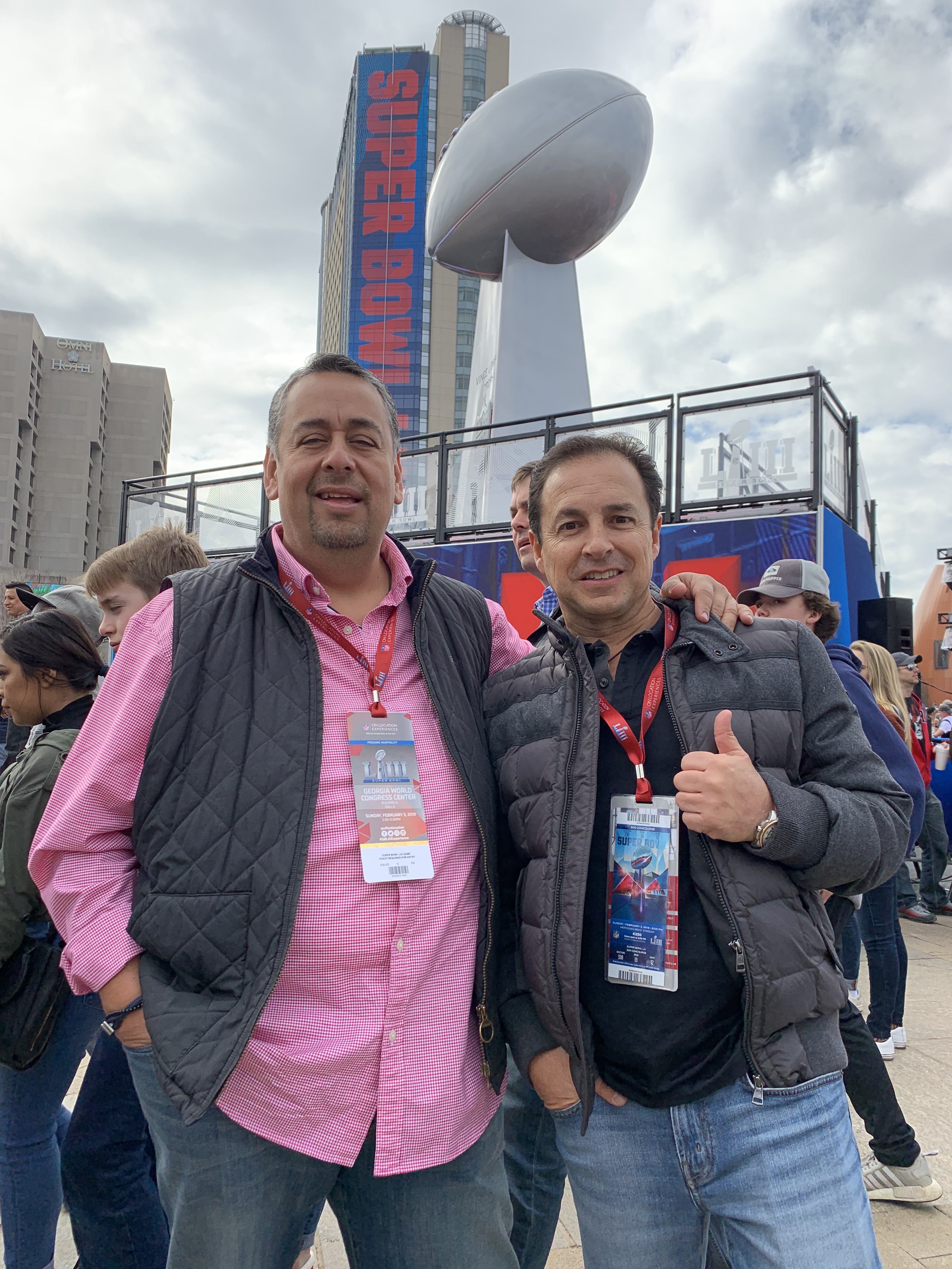 Juan Carlos -izq.- y Salvador posan frente a una reproducción gigante del trofeo Vince Lombardi. / Foto: Impremedia