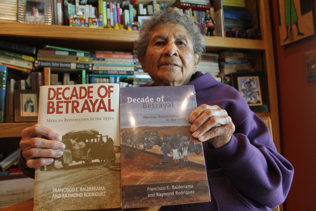 Emilia Castañeda, de 89 años de edad sostiene el libro “Década de la traición”, que habla de la repatriación de mexicanos en la década de 1930.