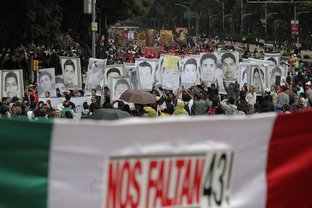 Miles marchan con pancartas en Ciudad de México en el aniversario de la desaparición de 43 estudiantes de la Escuela Normal Rural de Ayotzinapa.