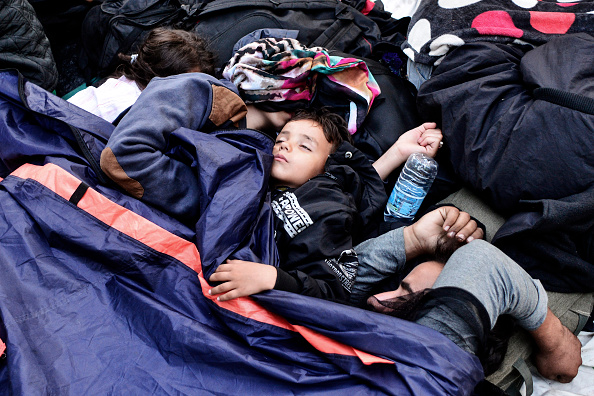 Un niño duerme entre otros refugiados en Victoria Square, Atenas, Grecia.