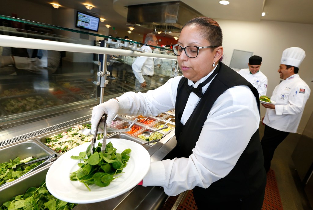 En la escuela también se instruye en cómo servir los platillos. La estudiante Suller Brown prepara una ensalada para la cafeteria de la escuela. /AURELIA VENTURA