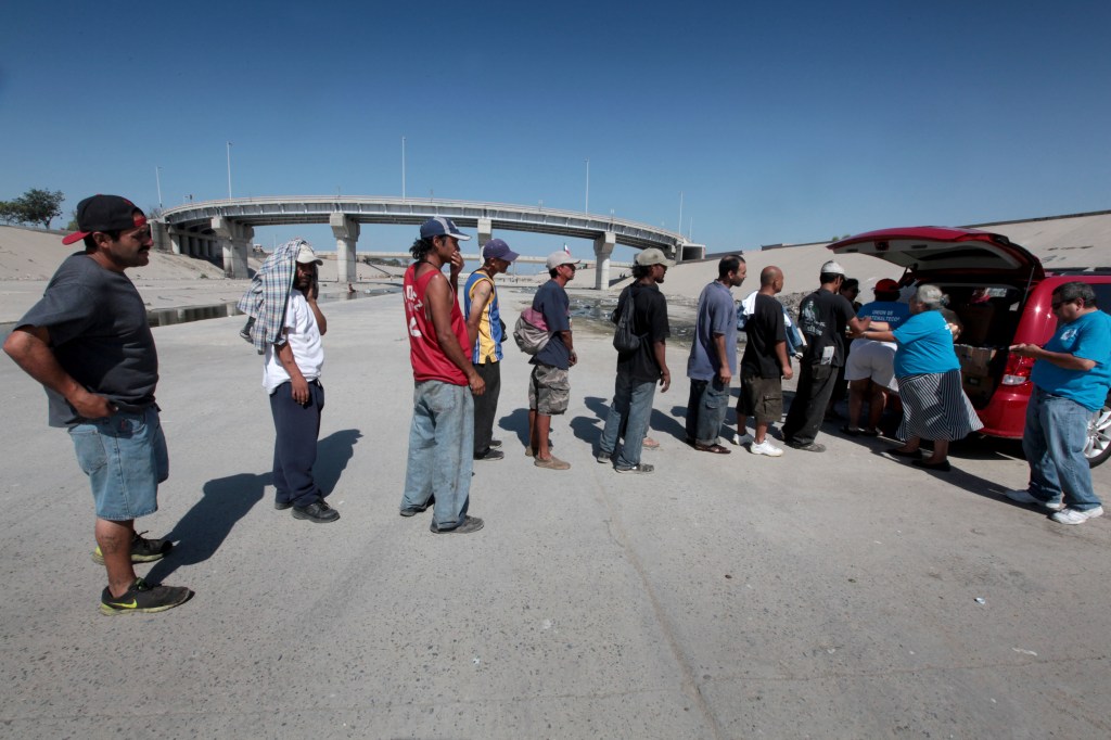 Inmigrantes indocumentados que viven en la zona conocida como " El Pozo " sobre el Río Tijuana reciben ayuda de la Unión de Guatemaltecos Emigrantes (UGE) / Aurelia Ventura