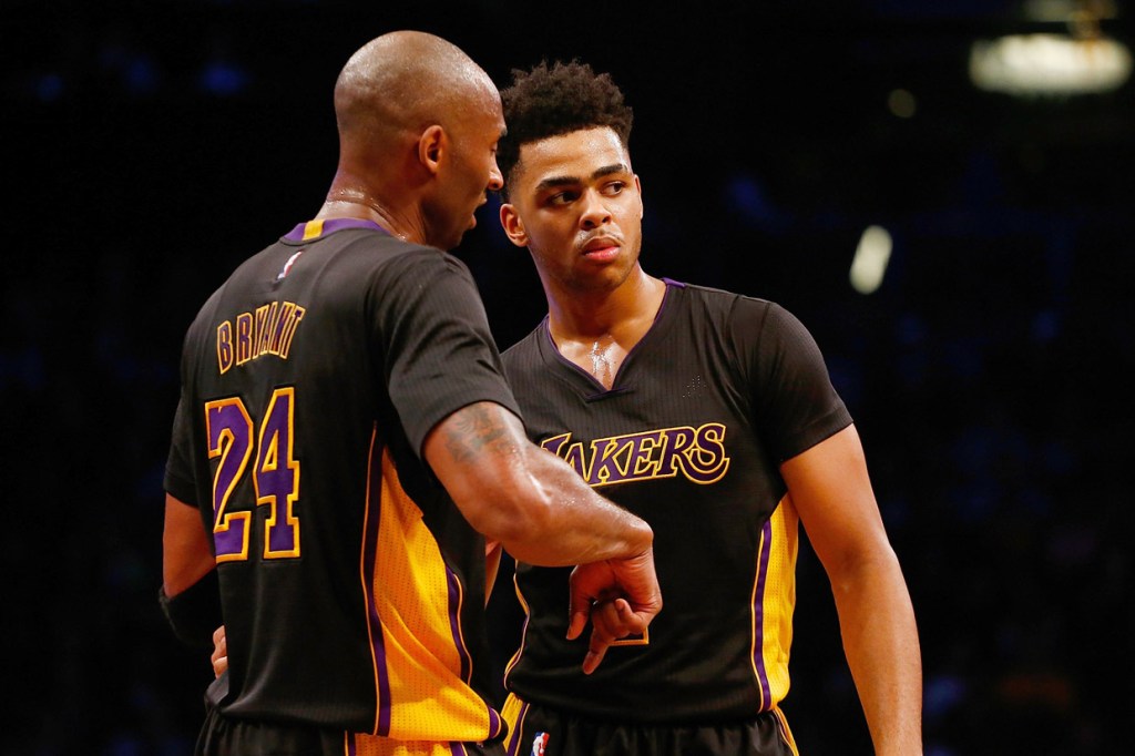 Bryant (izq.) habla con el rookie D'Angelo Russell durante el choque ante los Nets.