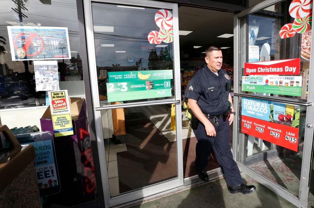 El agente Edwin Ayala sale de una tienda en Mission Hills donde habra uno de los posters policiales. /AURELIA VENTURA 