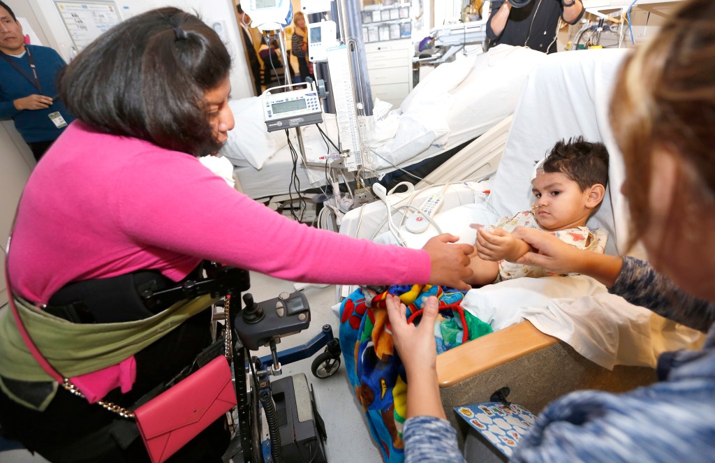 12/14/15 /LOS ANGELES/Formerly conjoined Guatemalan twins Josie (L) and Teresita Alvarez return to Mattel Children's Hospital to visit and give the gift of Christmas joy to 2 year-old Giovanny Hernandez. Guatemalan twins Josie and Teresita Alvarez returned to the medical staff who helped separate them in 2002.  (Photo by Aurelia Ventura/La Opinion)