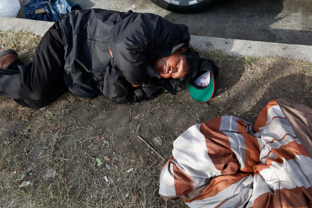 01/20/16 / LOS ANGELES/A homeless man sleeps next to an encampment near Wilshire and Hoover in Los Angeles. A growing number of displaced people are spreading out from downtown Los Angeles in an effort to escape the violence of skid row. (Photo by Aurelia Ventura/La Opinion)