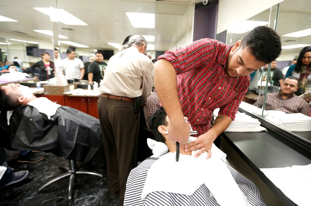 01/25/16 / DOWNEY/ Barber student Max Verderosa, 29, practices the technique blade shaving on fellow student Luis Romero while at Cosmetica School in Downey. (Photo by Aurelia Ventura/La Opinion)