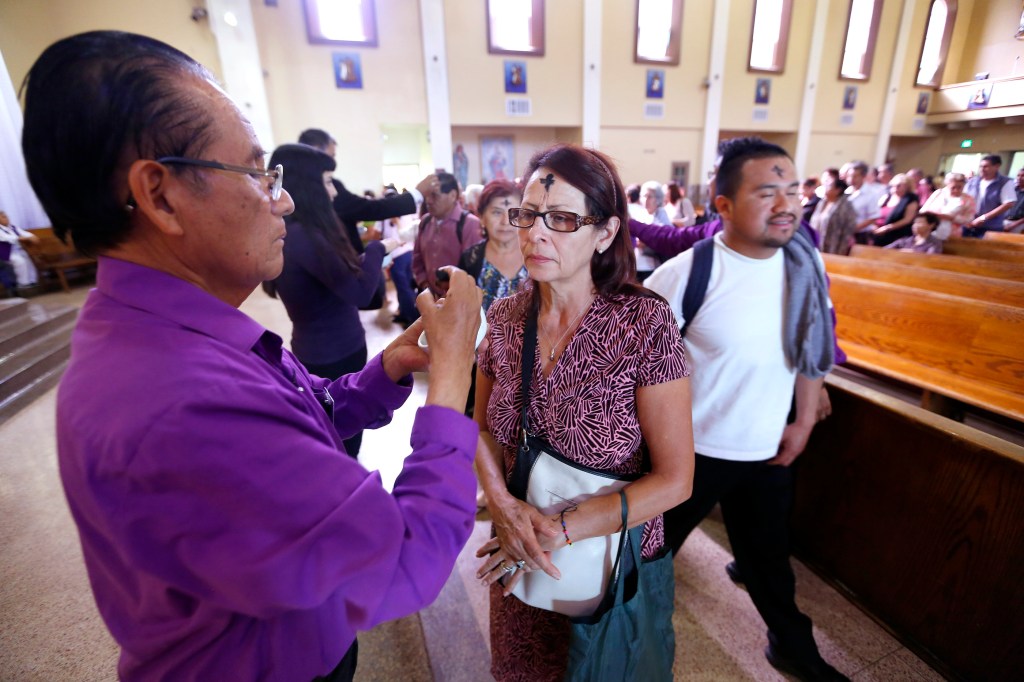 Personas reciben la cruz de ceniza durante una misa en la iglesia de la Placita Olvera. /AURELIA VENTURA