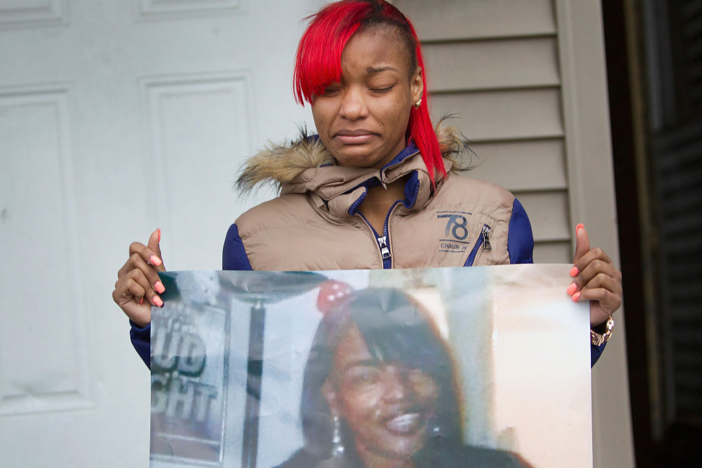 LaTonya Jones, hija de  Bettie Jones sostiene una fotografía de su madre durante una vigilia afuera de su casa, el 27 de diciembrte de 2015 en Chicago.