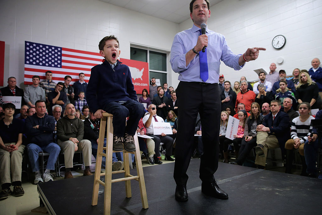 Dominick Rubio, 7, comparte con su padre, el aspirante a candidato presidencial republicano Sen. Marco Rubio (R-FL) el estrado en una de las asambleas de campaña, en la cafetería de la escuela primaria Mary A. Fisk, en Salem, New Hampshire.