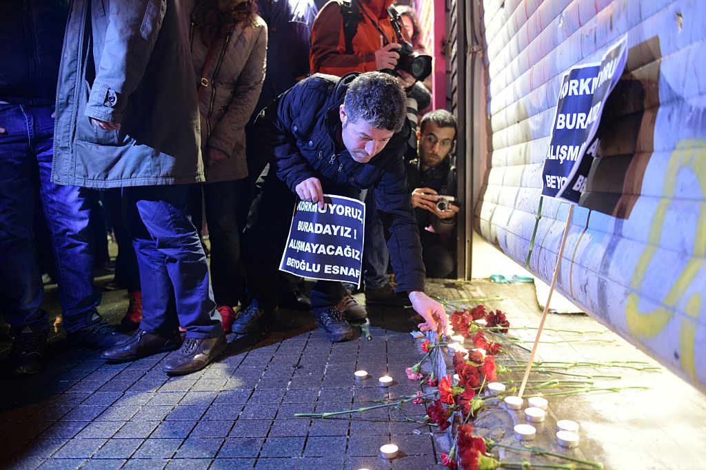 Un hombre enciende una vela en el lugar donde se realizó un atentado suicida en Estambul, Turquía.