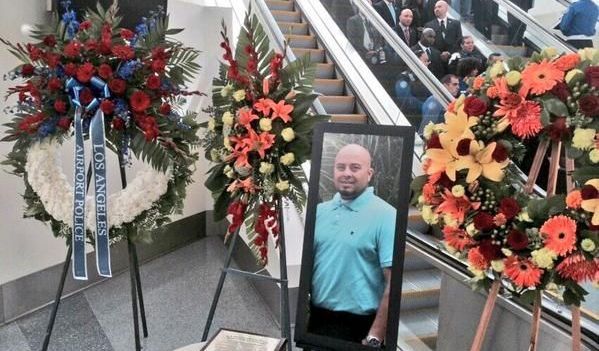 Una foto de Hernández aparece entre coronas de floras colocadas en el lugar del tiroteo.