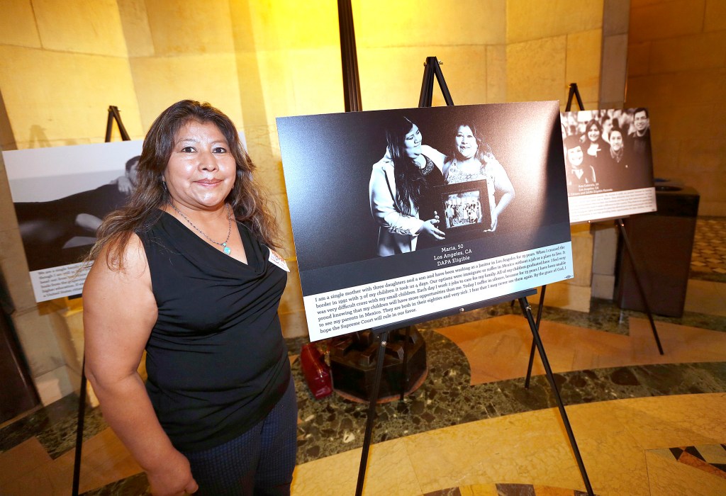 Maria Ortiz, de 50 años aparece junto al retrato que es parte de la exhibición itinerante. (Foto: Aurelia Ventura/ La Opinion)