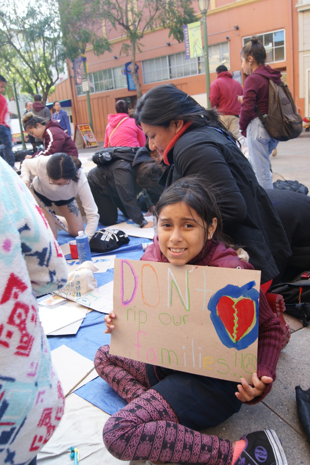 Jóvenes preparan carteles que usarán en la marcha del 1 de mayo en Oakland.
