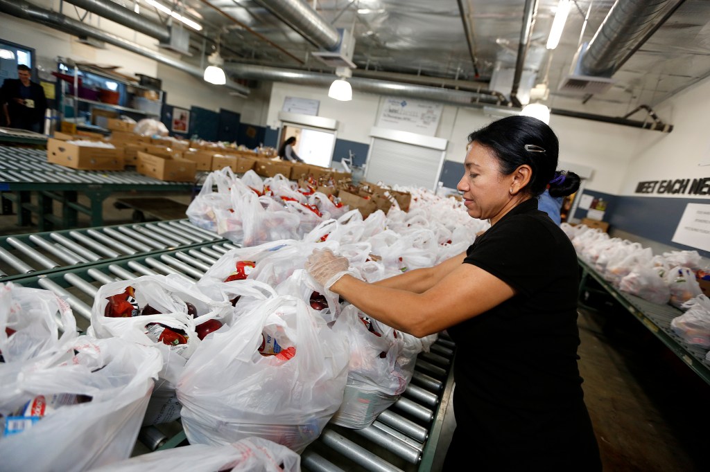 Danubia Alarcon, voluntaria de MEND, ayuda a preparar bolsas de comida para distribuir entre personas necesitadas. (Aurelia Ventura/La Opinion)