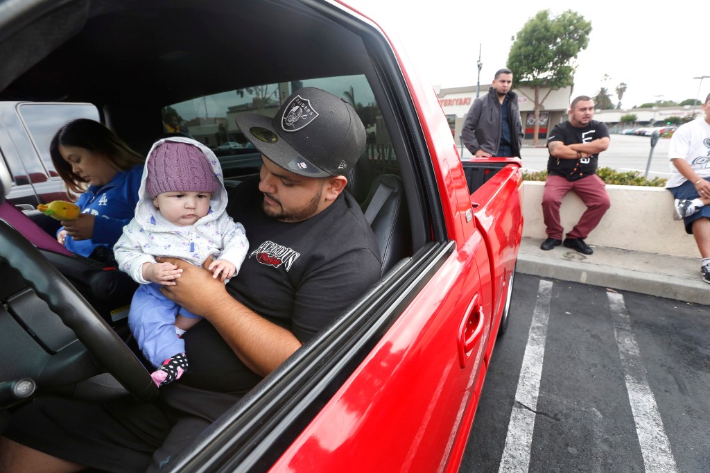 Alberto Muñoz, miembro de Hazardous Truckin, carga a su hija Valeria. y Mireya Ocegueda ( Aurelia Ventura/ La Opinion)