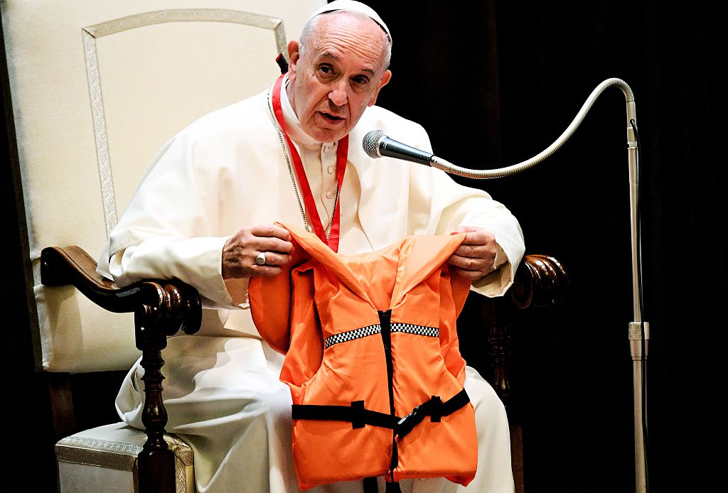 El papa Francisco muestra el chaleco salvavidas de una joven víctima se ahogó en el mar Mediterráneo tratando de llegar a Europa, durante una reunión con niños en el Vaticano. Foto: Getty
