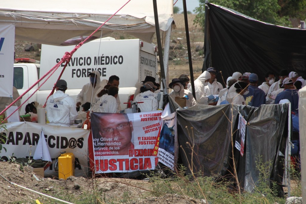 Peritos y familiares intentan sacar los cuerpos de la fosa común. Foto: Gardenia Mendoza Aguilar