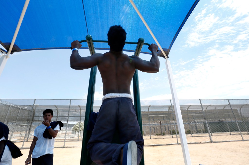 06/21/16/ ADELANTO/Detainees work out in the yard behind double fencing and barbed wire at the Adelanto Detention Center. The facility, the largest and newest Immigration and Customs Enforcement (ICE), detention center in California, houses males and females an average of 1,700 immigrants in custody pending a decision in their immigration cases or awaiting deportation. (Photo Aurelia Ventura/ La Opinion)