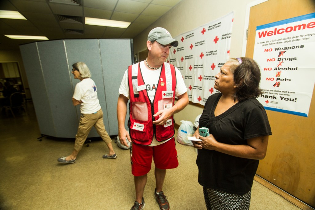 Michael McElrath (i) especialista en programas de desastres naturales de la Cruz Roja, conversa con una evacuada, en uno de los refugios instalados en Richmond. Foto: EFE