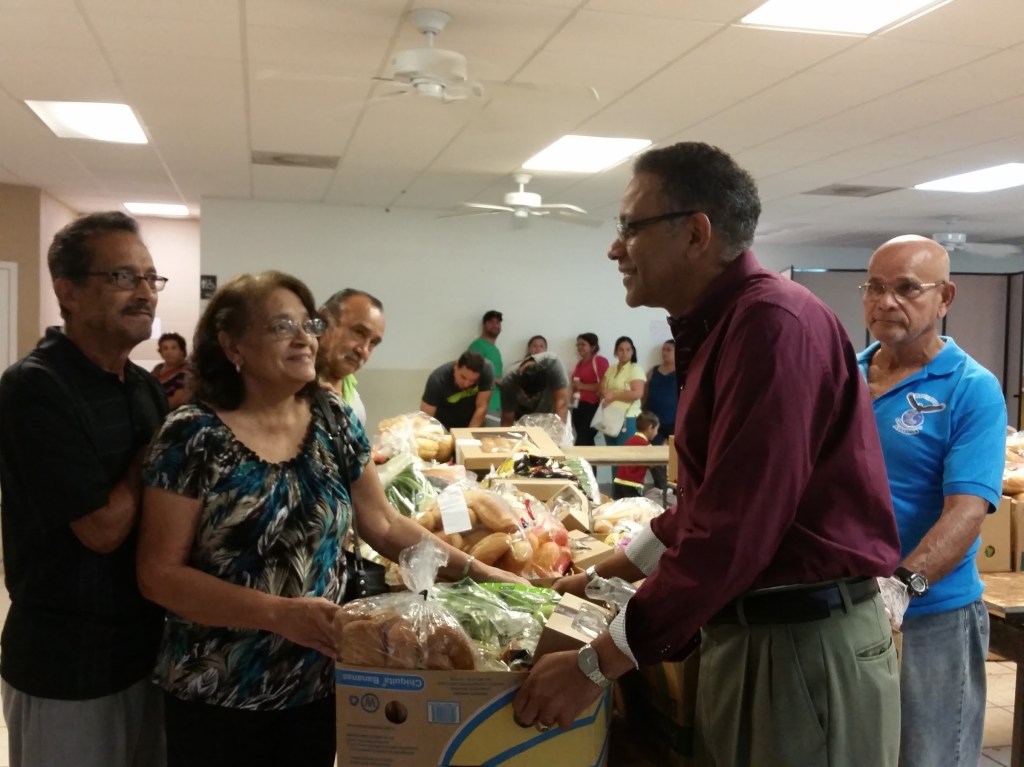 María y Leonardo León recibieron una caja de alimentos para prepararse ante la posible llegada del huracán Matthew a la Florida Central, de manos del pastor Jairo García, de la iglesia cristiana Renuevo en el área de Osceola.