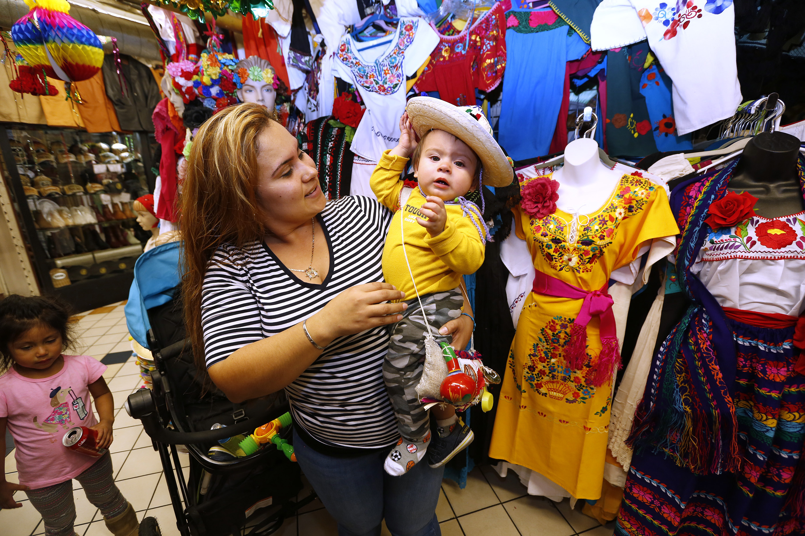 12/09/16 /LOS ANGELES/1 year-old Cesar Mateo with mom Guadalupe Erenas tries on an outfit while shopping at the popular Mercadito in East Los Angeles. Hundreds of religious Catholics will be celebrating the Virgin of Guadalupe. (Photo by Aurelia Ventura/La Opinion)
