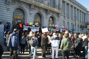 Manifestantes piden a las afueras de la Alcaldía de San Francisco que la ciudad continúe siendo un santuario para indocumentados y proteja a las comunidades inmigrantes y a las minorías.
