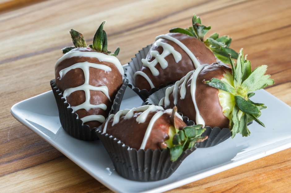 Los balones de futbol americanos de fresas cubiertas con chocolate son un postre clásico en las fiestas del Super Bowl.