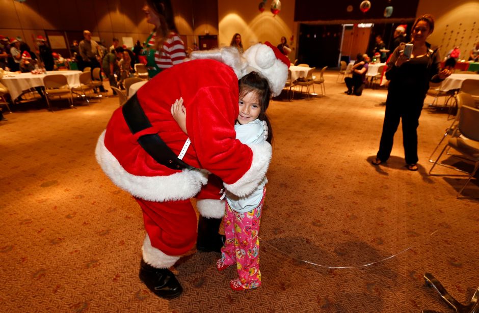 Emily Solis, de 5 años, recibe un abrazo de Santa. (Aurelia Ventura/La Opinion)