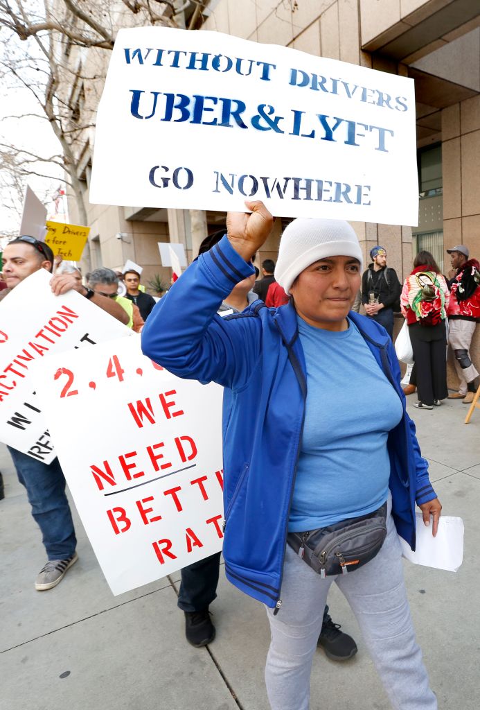 Decenas de manifestantes piden que Uber y Lyft destine más del cobro de los pasajeros a los conductores. (Aurelia Ventura/La Opinion)