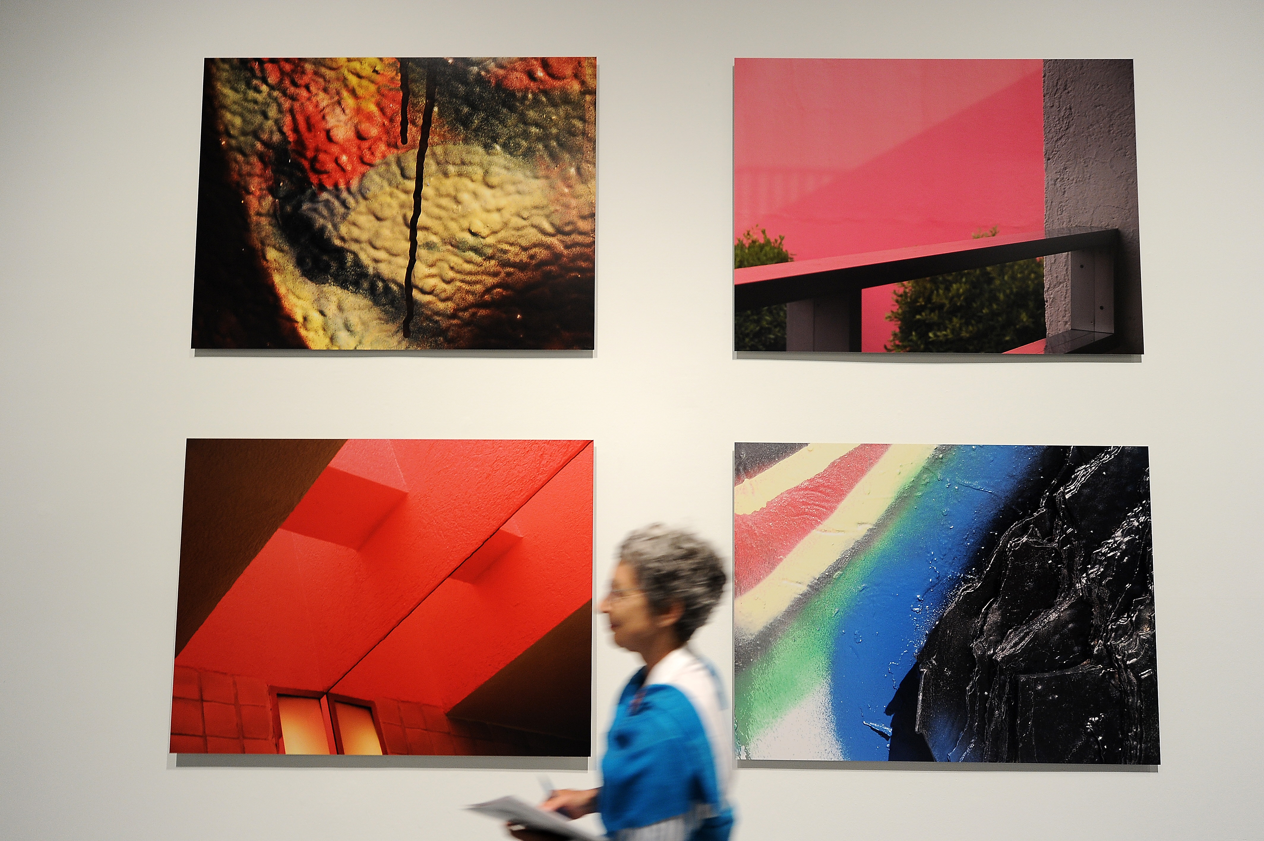 Un visitante pasa cerca de fotografías sobre metal instaladas en el Museo de Arte Contemporaneao (MOCA).